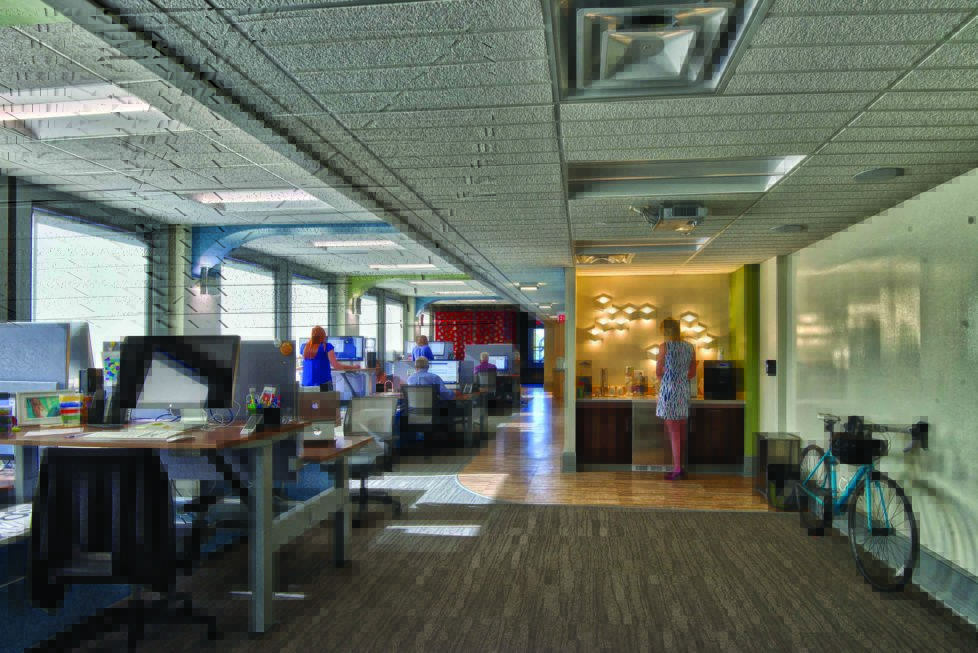 modern office layout with staff at their desks in a open floor plan, coffee bar, and bicycle in the foreground